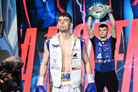 a boxer is standing on a stage holding a boxing trophy