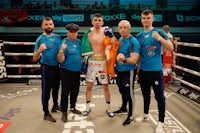 a group of boxers posing for a picture in a boxing ring