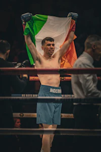 a boxer holding an irish flag in the ring